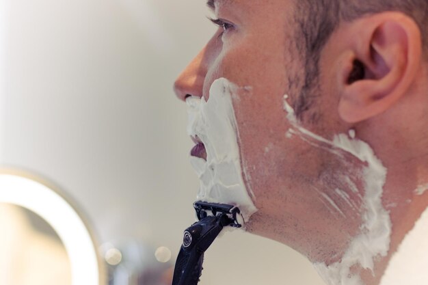 Foto primer plano de un hombre afeitándose en el baño