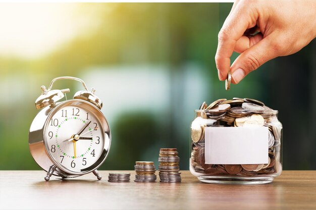 Foto un primer plano de un hombre apilando monedas de oro a mano con un fondo de bokeh verde