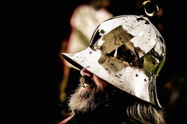 Foto primer plano de un hombre barbudo con casco de guerrero