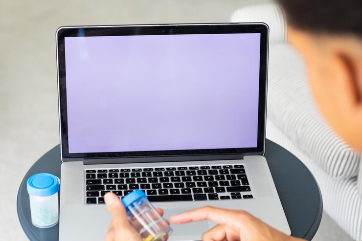Foto primer plano de un hombre biracial usando una computadora portátil con espacio de copia en la pantalla, sosteniendo medicamentos. servicios médicos, telemedicina, atención médica, comunicación y vida doméstica.