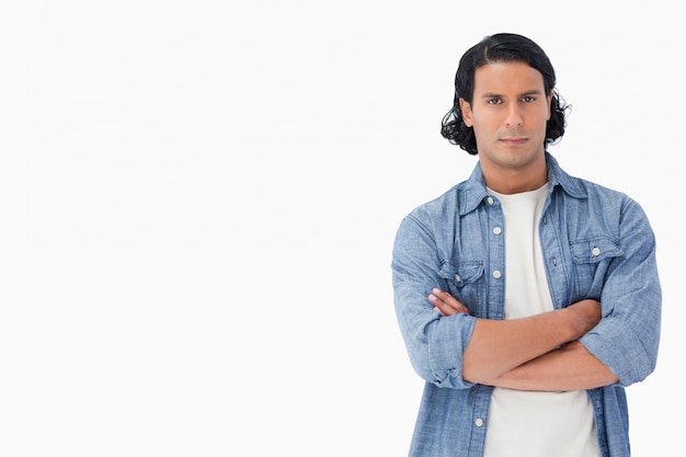 Primer plano de un hombre de cabello castaño cruzando sus brazos