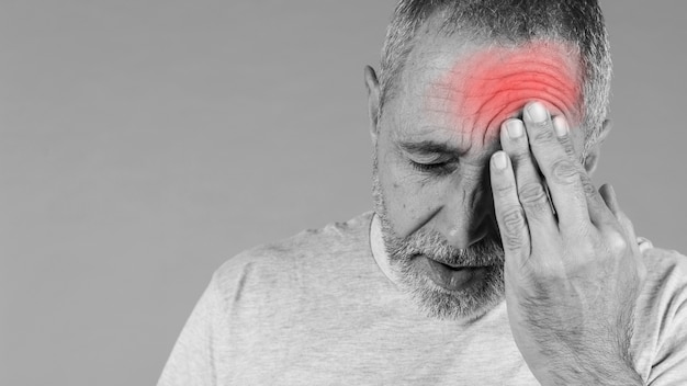 Foto primer plano de un hombre con la cabeza en el dolor