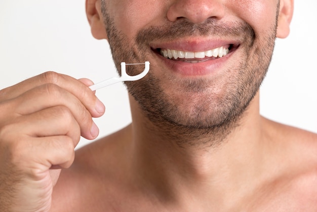 Primer plano del hombre sin camisa sonriente con hilo dental