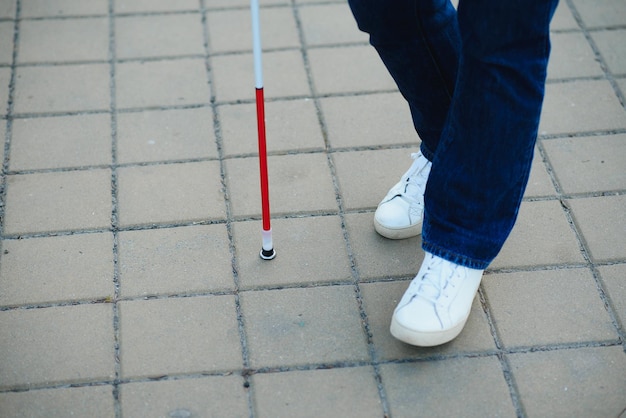 Primer plano de un hombre ciego de pie con palo blanco en la calle