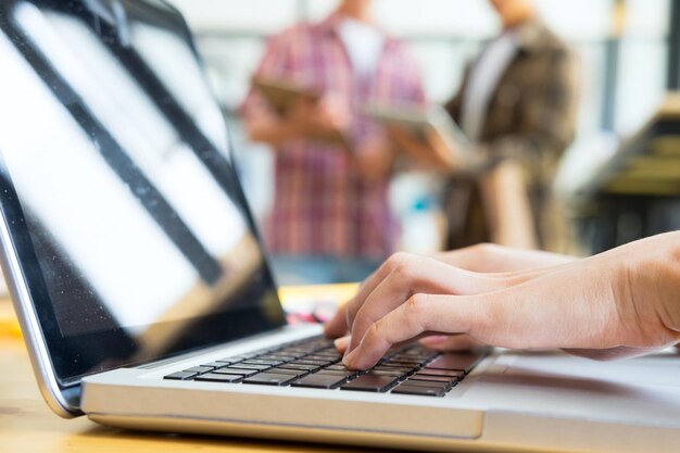 Foto primer plano de un hombre escribiendo en una computadora portátil