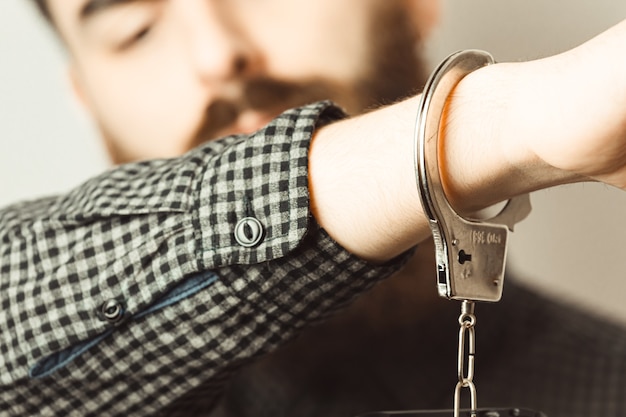 Un primer plano de un hombre esposado con luces brillantes