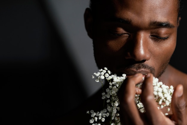 Foto primer plano hombre expresivo sosteniendo flores