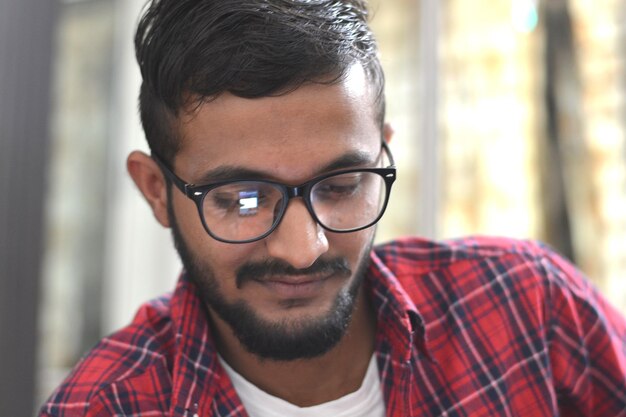 Foto primer plano de un hombre con gafas mirando hacia abajo