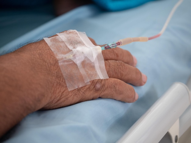 Foto primer plano de un hombre con un goteo intravenoso en el hospital