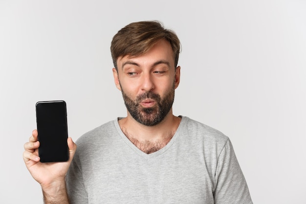 Primer plano de hombre guapo emocionado en camiseta gris