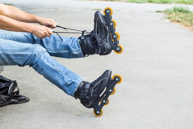 Primer plano de hombre hombre poniendo en patines al aire libre