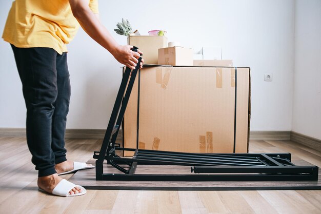 Primer plano de un hombre instalando muebles en su nueva casa