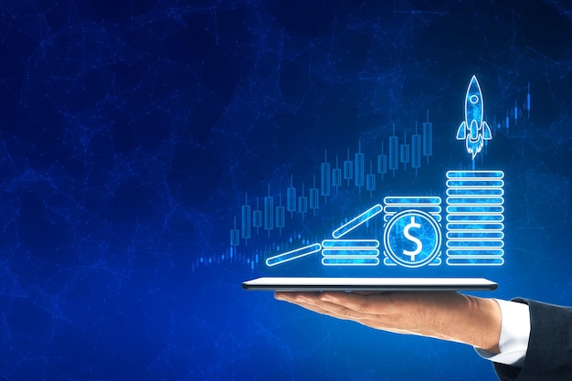 Primer plano de un hombre con una mano sosteniendo un teléfono inteligente con botas de nave espacial de comercio en crecimiento holograma con monedas digitales de dólar en un fondo azul borroso con un simulacro de lugar de inicio de comercio y concepto de ingresos