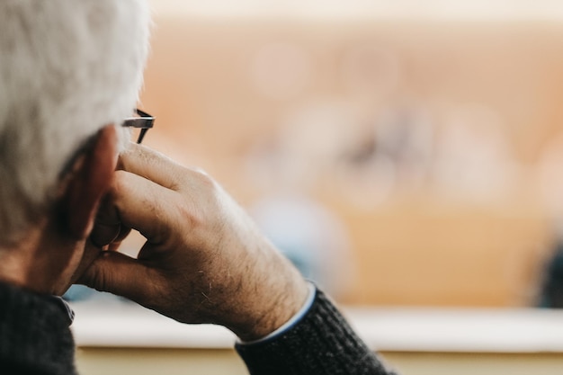 Primer plano de un hombre de mediana edad con canas por detrás con gafas