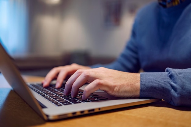 Primer plano de un hombre de negocios casual escribiendo en la computadora portátil