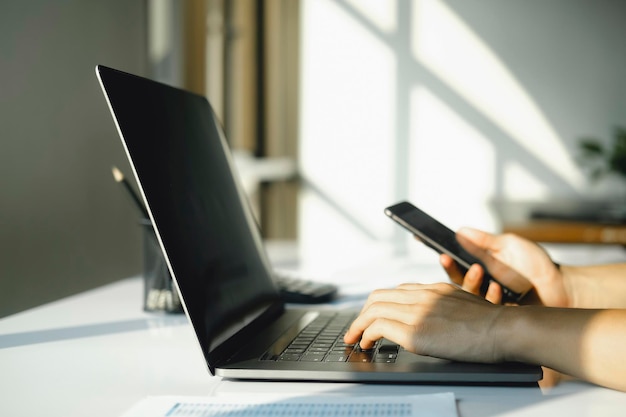 El primer plano del hombre de negocios está analizando la comercialización de acciones en teléfonos inteligentes y computadoras portátiles