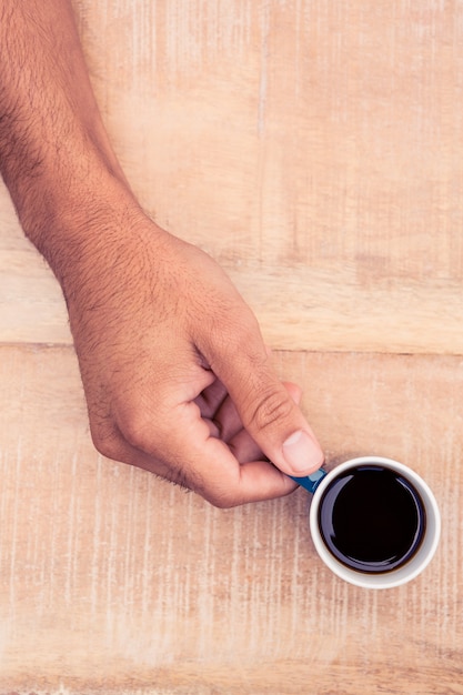 Primer plano, de, hombre de negocios, sostener el café, en el escritorio