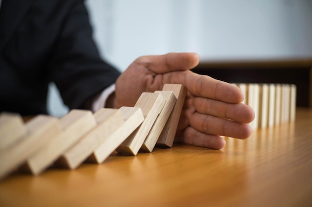 Primer plano de un hombre de negocios sosteniendo bloques de juguete en una mesa de madera