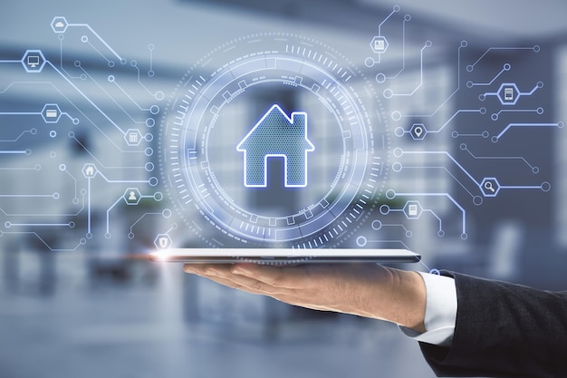 Primer plano de un hombre de negocios con una tableta en la mano con un icono de casa brillante creativo en el fondo borroso de la oficina con circuito de control remoto y concepto de hogar inteligente Doble exposición