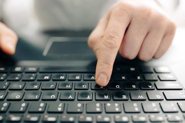 Primer plano de un hombre de negocios trabajando en una computadora portátil en un escritorio de madera como persona conceptual