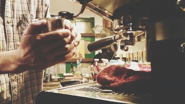 Primer plano de un hombre preparando comida en una cafetería