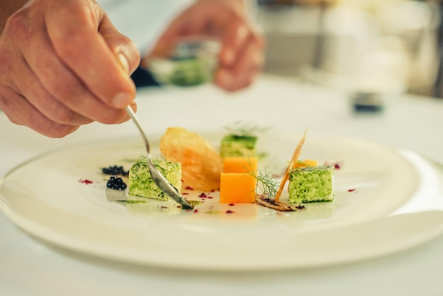 Primer plano de un hombre preparando comida en un plato