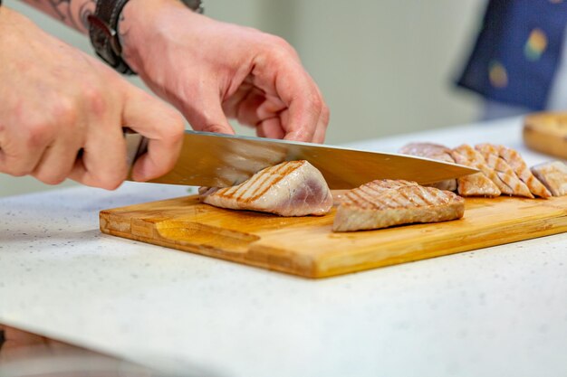 Primer plano de un hombre preparando comida en una tabla de cortar