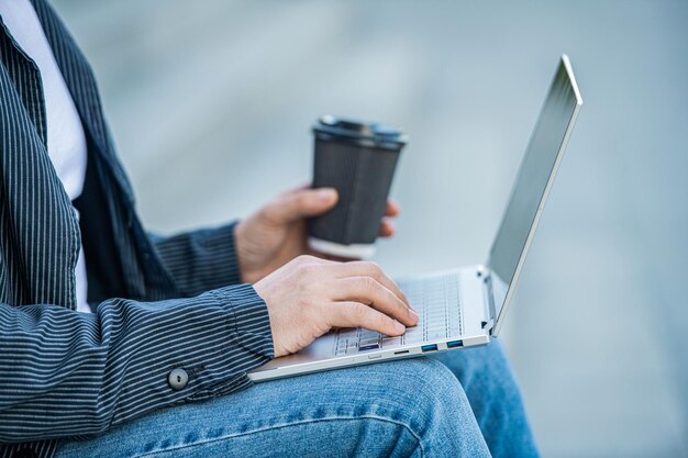 Primer plano de un hombre que bloguea en línea con una computadora fuera de la foto de un hombre que bloguea en línea con una computadora