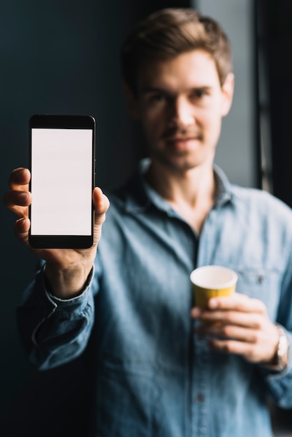 Primer plano de un hombre que muestra el teléfono celular con pantalla en blanco