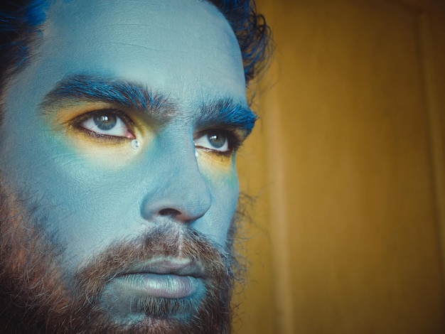 Primer plano de un hombre serio con la cara pintada