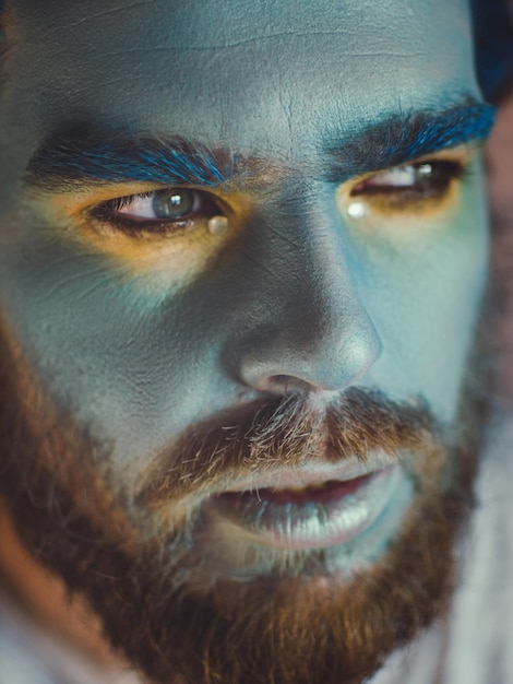 Primer plano de un hombre serio con la cara pintada