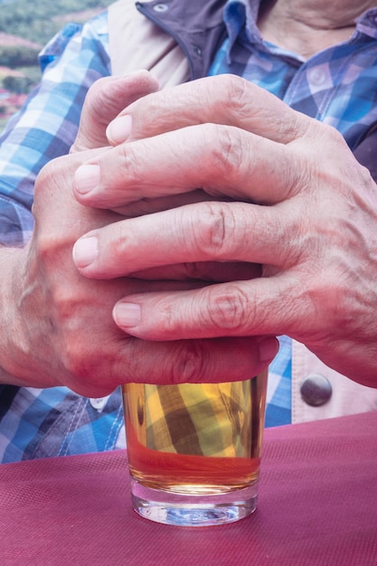 Foto primer plano de un hombre sosteniendo una bebida en un vaso en la mesa