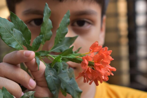 Foto primer plano de un hombre sosteniendo una planta con flores