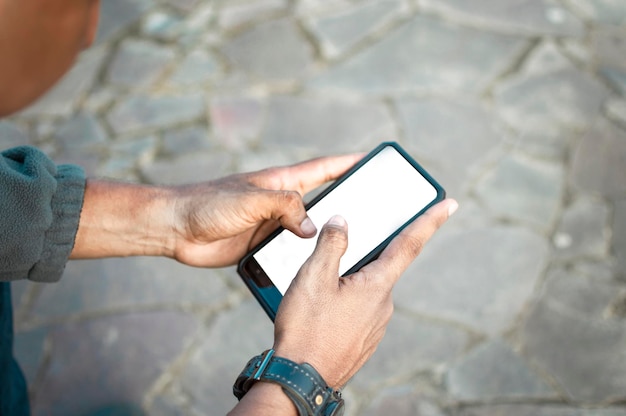 Primer plano de un hombre con teléfono celular en la mano, primer plano de una persona que controla su teléfono celular, chico joven con teléfono celular en la mano con espacio de copia