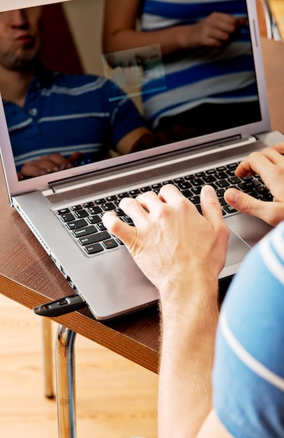 Foto primer plano de un hombre usando una computadora portátil en la mesa en casa