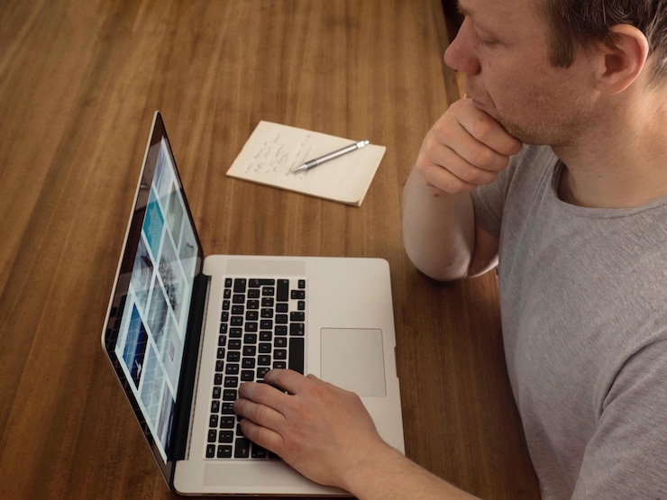 Foto primer plano de un hombre usando una computadora portátil en la mesa