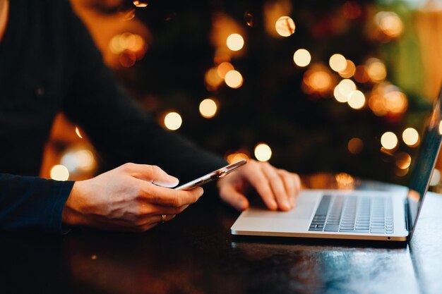 Primer plano de un hombre usando tecnologías en la mesa durante la noche