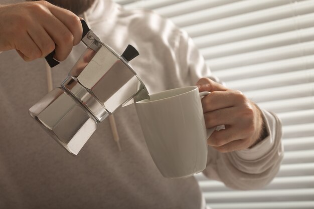 Primer plano de hombre vertiendo café en la oficina en concepto de día de verano de mañana vigorizante y positivo