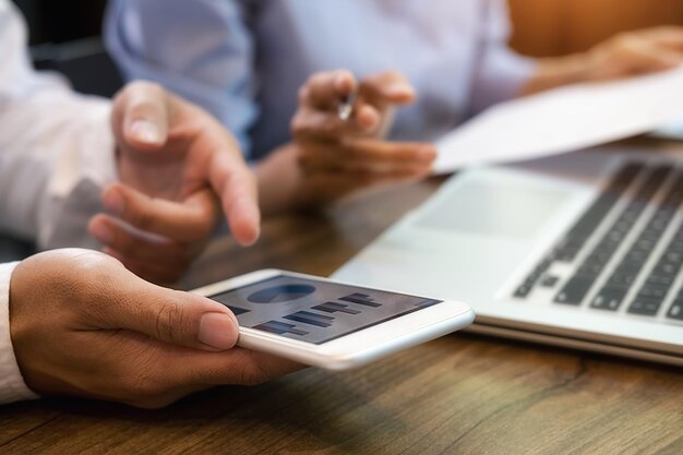 Foto primer plano de hombres de negocios usando el teléfono en el escritorio de la oficina