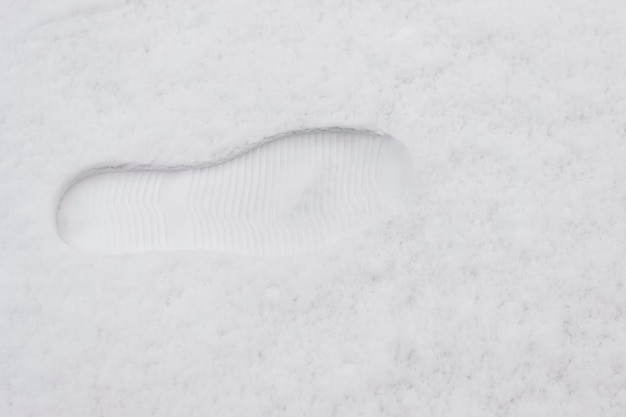 Primer plano de una huella de arranque en la nieve.