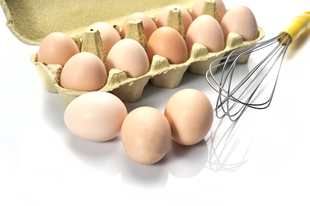 Primer plano de los huevos en dibujos animados sobre fondo blanco huevos de gallina cruda en caja de huevos alimentos orgánicos para una buena salud alta en proteínas