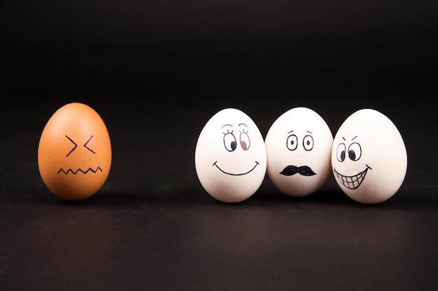Primer plano de huevos de Pascua con caras sonrientes sobre un fondo gris