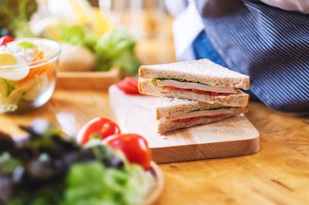 Foto primer plano de la imagen de una mujer chef cocinar sándwich de trigo integral en la cocina