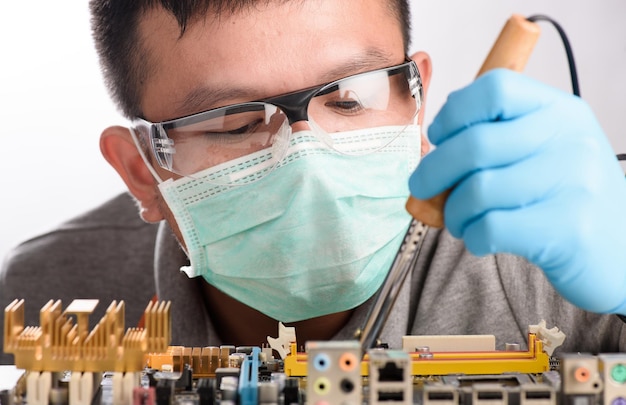 Primer plano de un ingeniero reparando una placa de circuito