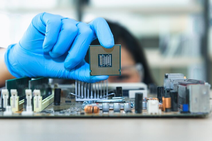 Foto primer plano del ingeniero sosteniendo el equipo informático sobre la mesa