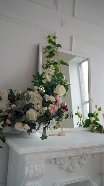 Primer plano del interior de una de las esquinas de la habitación Espejo grande con flores decorativas y velas en la mesa blanca