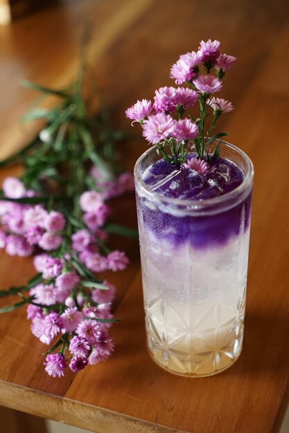 Primer plano de un jarrón de flores púrpura en la mesa