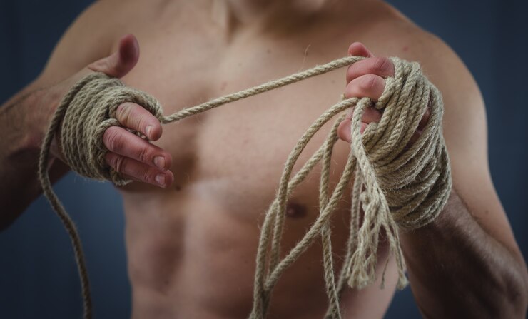 Foto primer plano de un joven boxeador tailandés manos cuerdas de cáñamo se envuelven antes de la pelea o entrenamiento