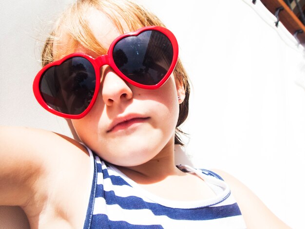 Foto primer plano de joven caucásica tomando el sol con gafas de sol