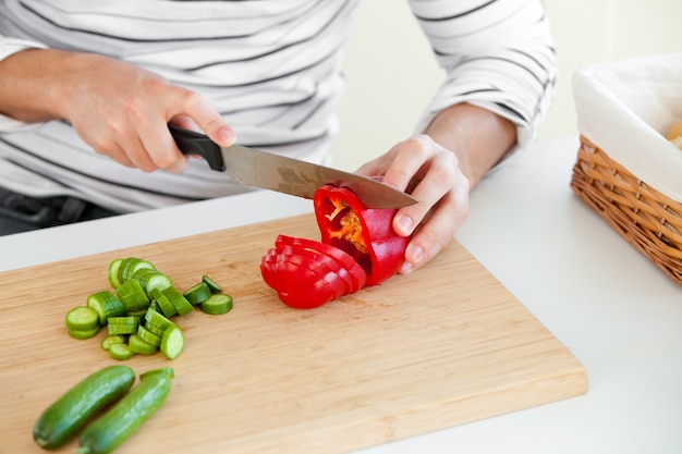 Primer plano de un joven corte de verduras en la cocina